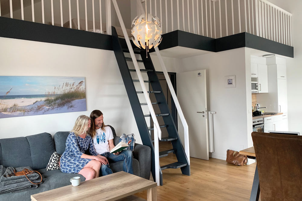 Feriengäste im Wohnbereich lesen ein Buch